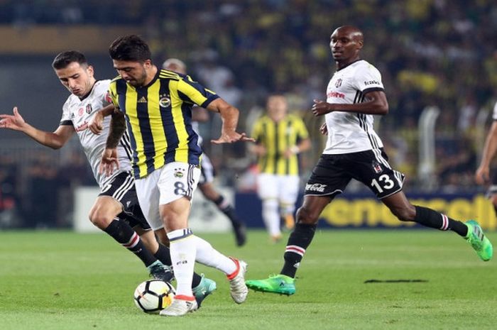 Pemain Fenerbahce,Ozan Tufan, menggiring melewati pemain-pemain Besiktas, Sabtu (23/9/2017).