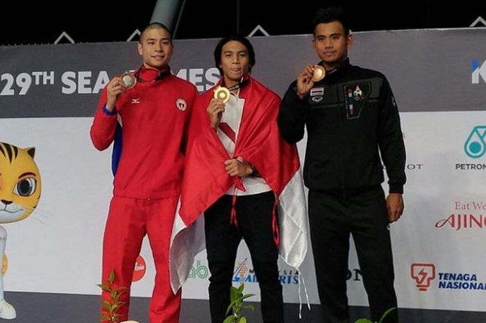 Perenang Indonesia, Gagarin Nathaniel (tengah), meraih medali emas dari nomor lomba 100 meter gaya dada putra, pada ajang SEA Games 2017 di Kuala Lumpur, Malaysia, Jumat (25/8/2017).