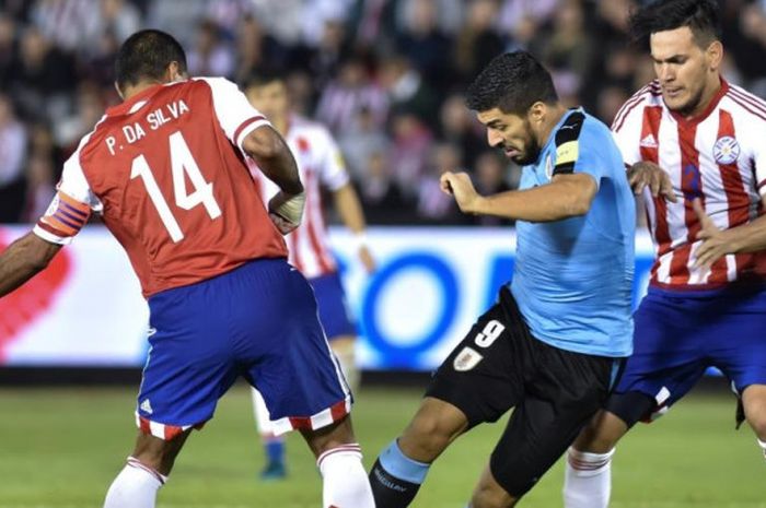 Penyerang timnas Uruguay, Luis Suarez (tengah), berusaha melewati dua pemain Paraguay dalam partai Kualifikasi Piala Dunia 2018 di Asuncion, 5 September 2017.