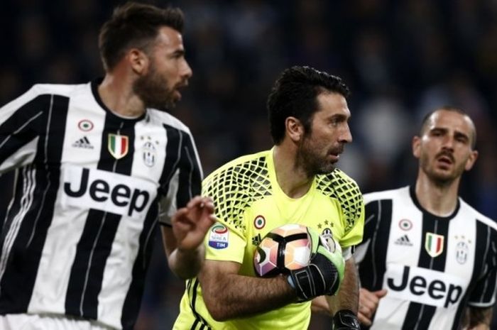 Kiper Juventus, Gianluigi Buffon (tengah), diapit oleh bek Andrea Barzagli (kiri) dan Leonardo Bonucci beraksi dalam laga Serie A kontra AC Milan di Stadion San Siro, Milan, 10 Maret 2017.