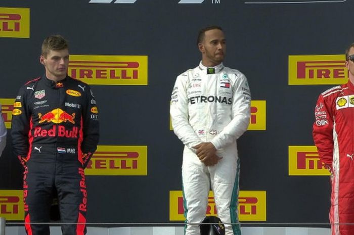 Pemenang balapan GP Prancis, Lewis Hamilton (Mercedes/tengah), menaiki podium bersama dengan pengisi posisi tiga besar lainnya, Max Verstappen (Red Bull Racing/kiri), dan Kimi Raikkonen (Ferrari).