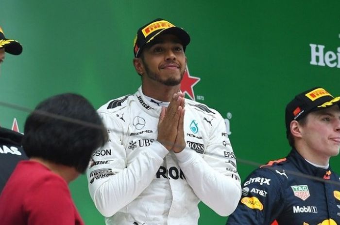 Pebalap Mercedes, Lewis Hamilton (tengah), bereaksi di atas podium setelah finis di urutan pertama pada GP China yang berlangsung di Sirkuit Internasional Shanghao, Minggu (9/4/2017).