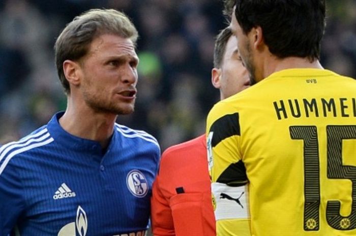 Kapten tim Schalke, Benedikt Hoewedes (kiri), beradu argumentasi dengan skipper Borussia Dortmund, Mats Hummels.