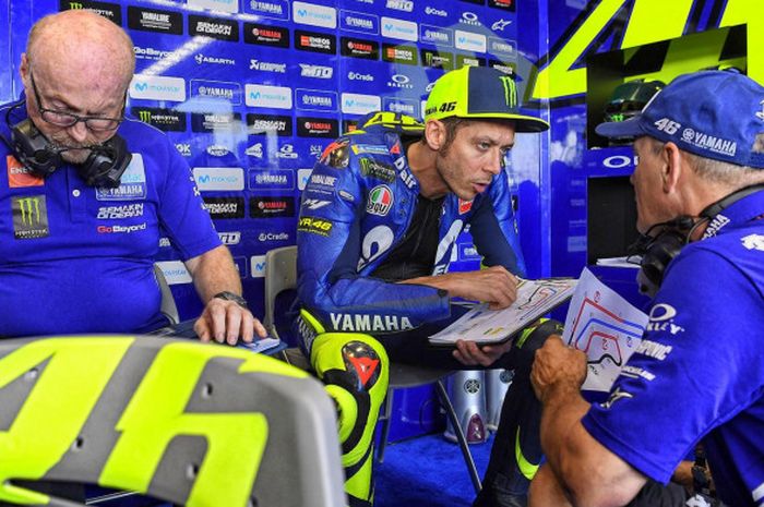 Valentino Rossi sedang berdiskusi bersama kru tim Movistar Yamaha.