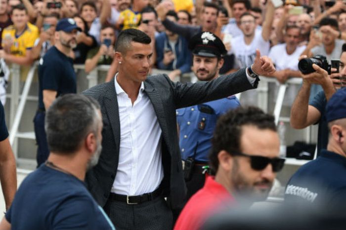 Pemain baru Juventus, Cristiano Ronaldo, melambaikan tangan kepada para suporter saat tiba untuk melakukan tes medis di markas klub di Stadion Allianz, Turin, Senin (16/7/2018).