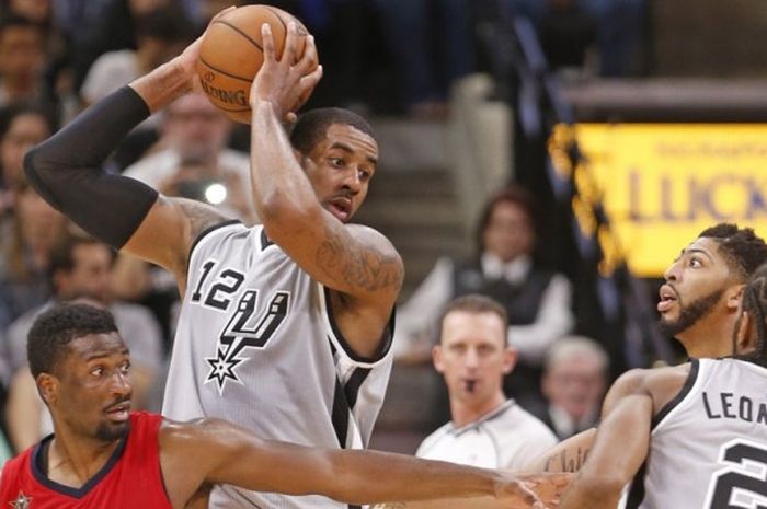 Pebasket San Antonio Spurs, LaMarcus Aldridge (jersey abu-abu, #12), bersiap mengoper bola kepada rekannya, Kawhi Leonard (#2). Aldrigde mendapat penjagaan ketat dari pemain New Orleans Pelicans, Solomon Hill (kiri) dan Anthony Davis, saat menjalani laga musim reguler di AT&T Center, San Antonio, Texas, Amerika Serikat, Sabtu (29/10/2016) malam waktu setempat atau Minggu pagi WIB.