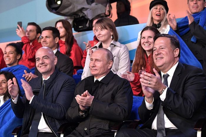 Presiden Rusia, Vladimir Putin (tengah), saat menonton gala konser opera dunia di Red Square, Moskow, pada Rabu (13/6/2018). Tampak juga sosok presiden FIFA, Gianni Infantino, di sebelah kiri Putin.