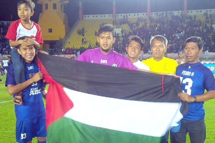 Penjaga gawang tim sepak bola Jawa Barat, Muhammad Natshir, membawa bendera Palestina saat merayakan keberhasilannya mempersembahkan mendali emas di ajang Pekan Olahraga Nasional (PON) XIX 2016.