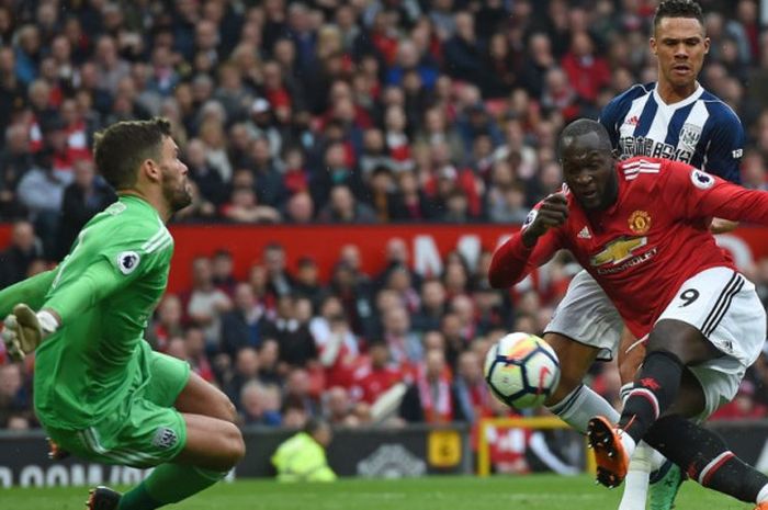 Pemain Manchester United, Romelu Lukaku, melepas tembakan ke arah kiper West Bromwich Albion, Ben Foster, pada laga Liga Inggris di Stadion Old Trafford, Minggu (15/4/2018).