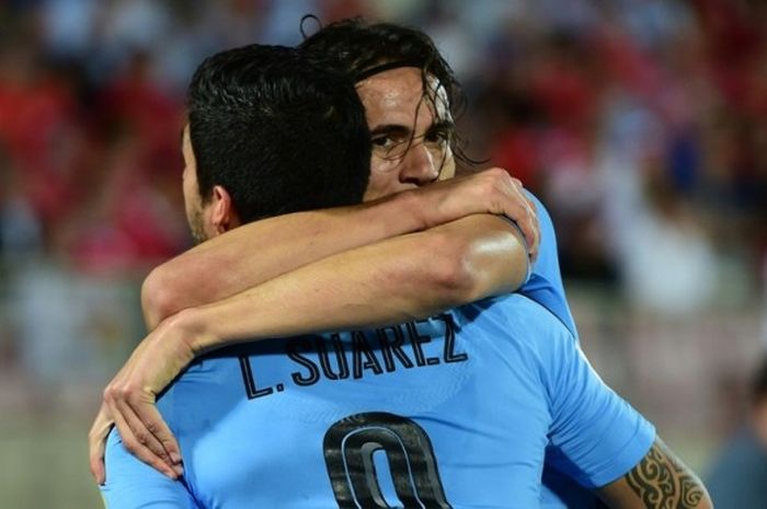 Penyerang Uruguay, Edinson Cavani, memeluk Luis Suarez saat melakukan selebrasi seusai menjebol gawang Cile dalam laga Kualifikasi Piala Dunia 2018 zona Amerika Selatan di Stadion Nacional Julio Martinez Pradanos, Santiago, Cile, 15 November 2016.