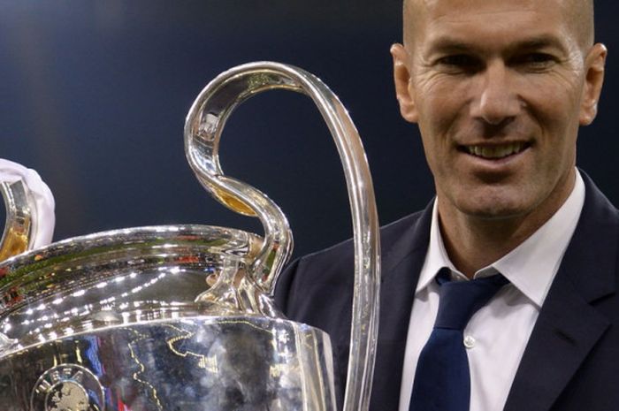    Pelatih Real Madrid, Zinedine Zidane, berpose dengan trofi Liga Champions seusai mengalahkan Juventus dalam partai final di The Principality Stadium, Cardiff, Wales, pada 3 Juni 2017.   