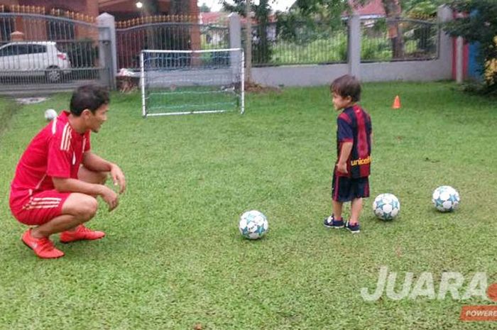 Donny Fernando Siregar memperkenalkan sepak bola kepada putranya, El Nino Inesta, yang berusia 4 tahun di halaman rumahnya.
