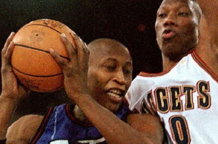 Pebasket Toronto Raptors, Clifford Rozier, berupaya melewati penjagaan pemain Denver Nuggets, Ervin Johnson, pada laga musim reguler NBA 1996-1997 di McNichols Sports Arena, Denver, Colorado, Amerika Serikat, 25 Februari 1997.