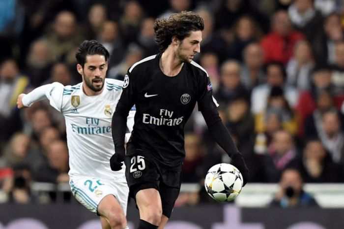 Gelandang Paris Saint-Germain, Adrien Rabiot (kanan), berduel dengan pemain Real Madrid, Isco, dalam laga leg pertama babak 16 besar Liga Champions di Stadion Santiago Bernabeu, Madrid, Spanyol, pada 14 Februari 2018.