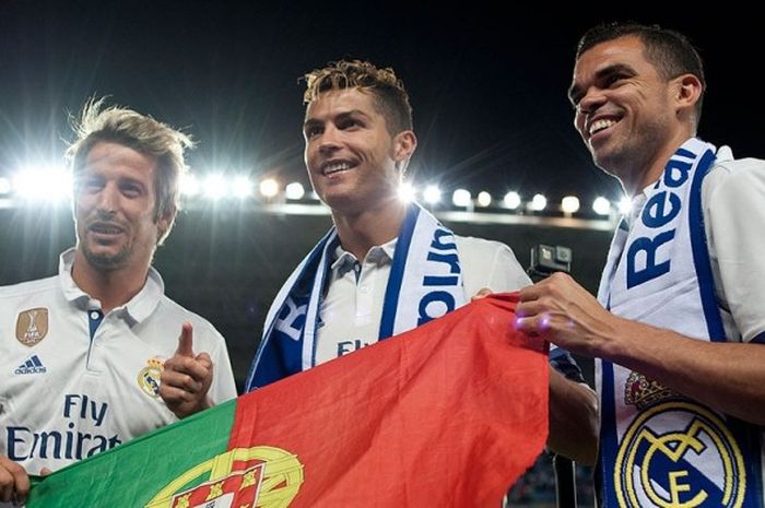 Tiga pemain Real Madrid asal Portugal, Fabio Coentrao, Cristiano Ronaldo, dan Pepe, berpose memegang bendera Portugal saat merayakan sukses Real Madrid merebut tital juara La Liga seusai mengalahkan Malaga di Stadion La Rosaleda, Malaga, (21/5/2017).