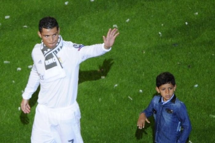 Cristiano Ronaldo membawa anaknya, Cristiano Ronaldo Jr, saat perayaan Real Madrid menjuarai final Liga Champions di Stadion Santiago Bernabeu, 29 Mei 2016.