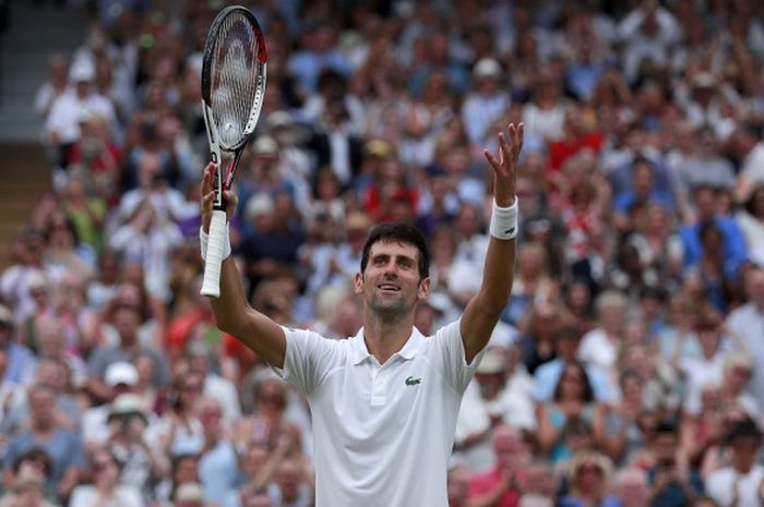 Petenis tunggal putra Serbia, Novak Djokovic, melakukan selebrasi yang menjadi ciri khasnya seusai memenangi laga semifinal Wimbledon 2018 atas Rafael Nadal (Spanyol) dengan skor 6-4, 3-6, 7-6 (11-9), 3-6, 10-8 di All England Lawn Tennis Club, London, Inggris, Sabtu (14/7/2018).