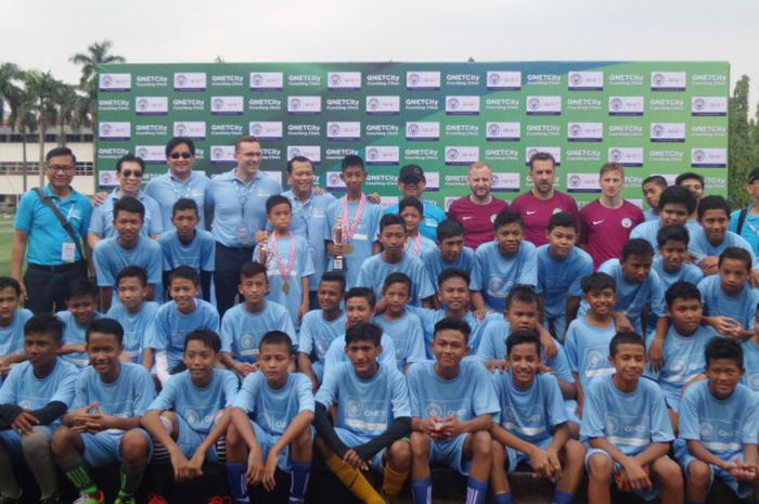 Tiga pelatih dari City Football Schools berpose bersama gelombang pertama dari anak-anak Jakarta Rusun Festival dalam QNET City coaching clinic di lapangan Pertamina Simprug, Jakarta, Sabtu (22/7/2017).