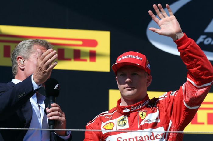 Kimi Raikkonen melambaikan tangan di podium usai balapan Grand Prix Hungaria, Minggu (30/7/2017).