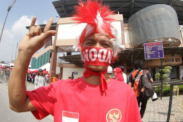 salah satu suporter timnas indonesia mengenakan penutup kepala dan syal indonesia pada pertandingan indonesia vs timor leste