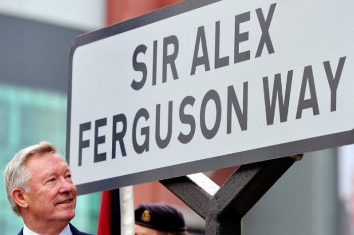 Mantan manajer Manchester United, Sir Alex Ferguson, berpose di sebuah tanda jalan dekat Stadion Old Trafford, Manchester, pada 14 Oktober 2013.