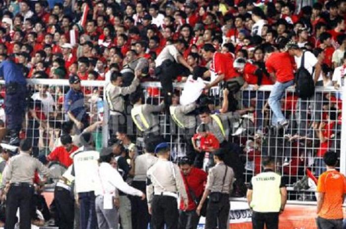 Sejumlah suporter Timnas Indonesia dievakuasi petugas, akibat tak kuat berdesak-desakan di dalam tribun penonton, saat menyaksikan partai final cabang olahraga sepak bola SEA Games, di Stadion Utama Gelora Bung Karno, Senin (21/11/2011).