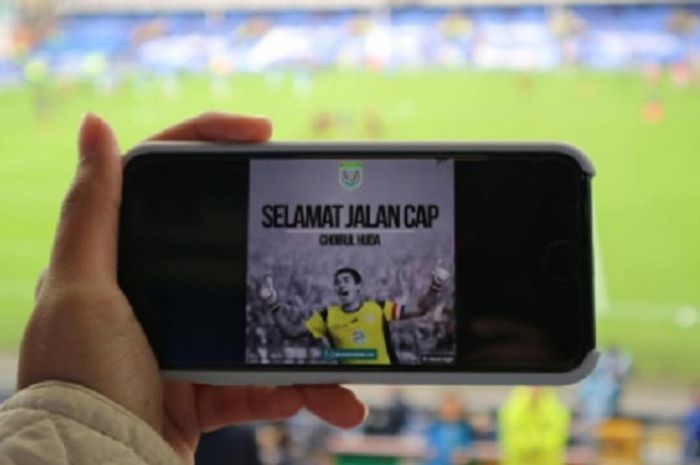 Seorang suporter asal Indonesia Ganis Rumpoko memperlihatkan foto Choirul Huda saat laga Everton vs Arsenal di Stadion Goodison Park.