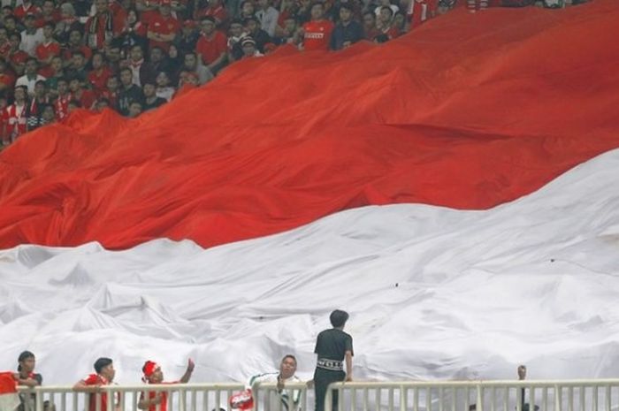 Suporter Indonesia membentangkan bendera Merah-Putih berukuran raksasa pada final pertama Piala AFF 2016 antara Indonesia dan Thailand di Stadion Pakansari, Cibinong, Kabupaten Bogor, Rabu (14/12/2016).    