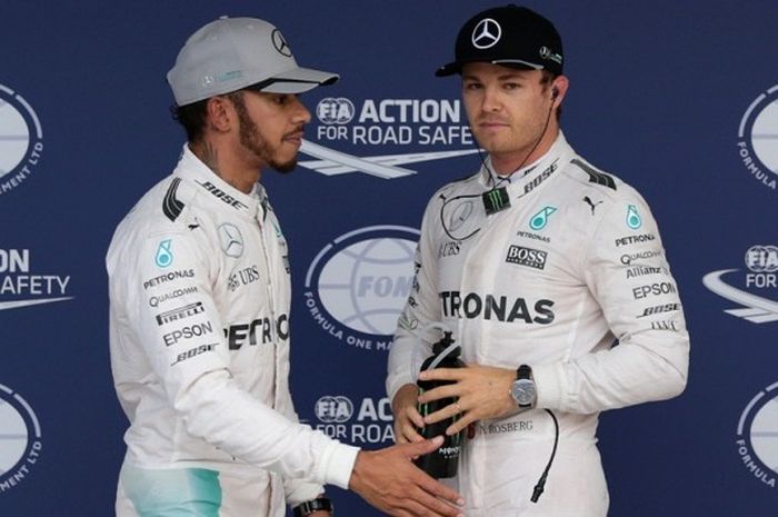 Pebalap Mercedes AMG Petronas F1 Team asal Jerman, Nico Rosberg (kanan), dan rekan satu timnya asal Inggris, Lewis Hamilton, bereaksi setelah menyelesaikan sesi kualifikasi GP Jepang di Sirkuit Suzuka, Sabtu (8/10/2016).