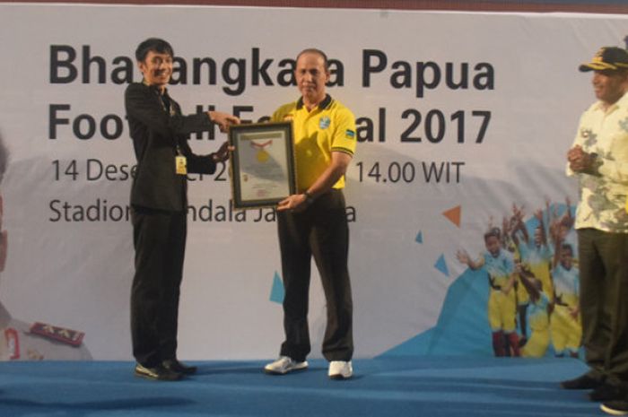 Perwakilan MURI, Triyono, menyerahkan piagam tanda rekor coaching clinic dengan 1.030 anak kepada Kapolda Papua, Boy Rafli Amar, di Stadion Mandala Jayapura, Kamis (14/12/2017).