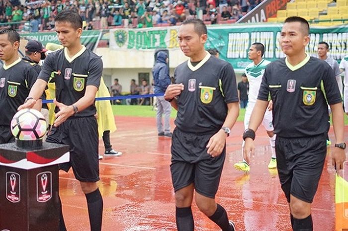 Wasit Thoriq Alkatiri (memegang bola) saat akan memimpin laga PSMS Medan versus Persebaya pada babak 8 besar Piala Presiden 2018 di Stadion Manahanh, Solo.