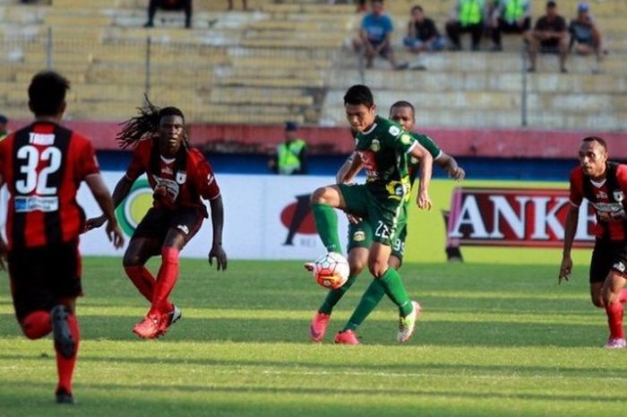 Aksi gelandang Bhayangkara Surabaya Unitedm Fandi Eko Utomo (tengah) saat menguasai bola di tengah kepungan pemain Persipura Jayapura pada pekan ke-14 Kejuaraan Sepak Bola Torabika di Stadion Gelora Delta, Sidoarjo, pada Jumat (5/8/2016).