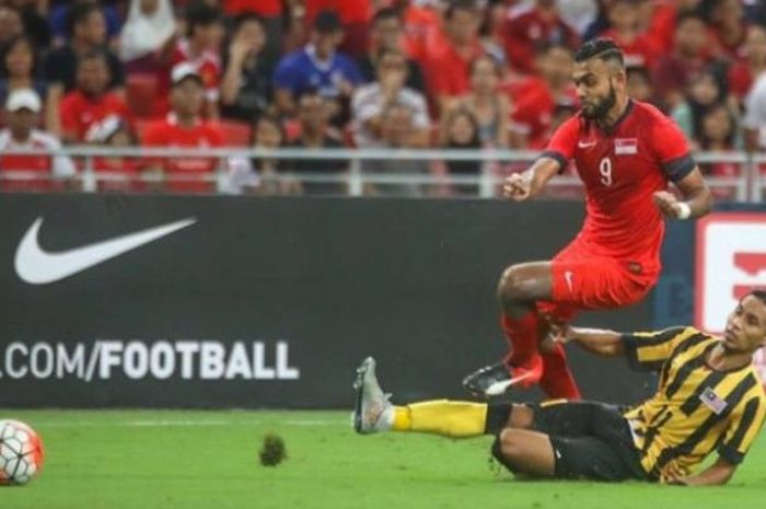 Gelandang Malaysia, Baddrol Bakhtiar (bawah) mencoba menghalangi laju pemain bertahan Singapura, Faritz Abdul Hameed di Stadion Nasional Singapura, Jumat (7/10/2016) malam. 