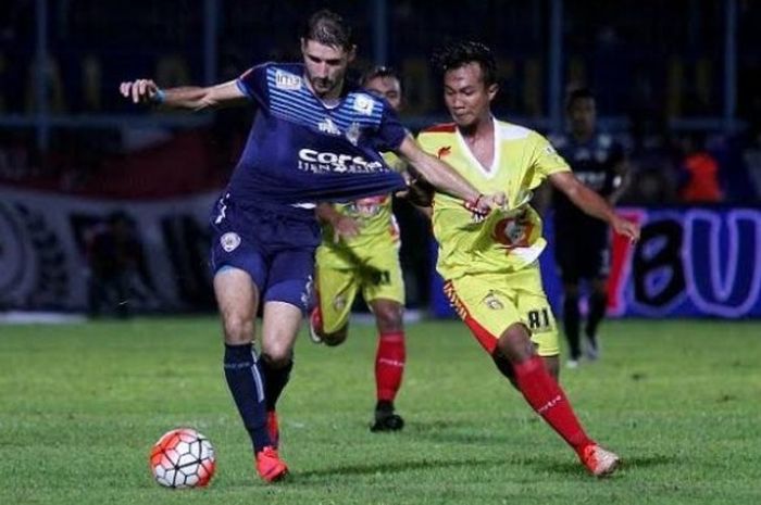 Gelandang BSU, Muhammad Hargianto (kanan) saat berebut bola dengan gelandang asing Arema, Srdjan Lopicic, di Stadion Kanjuruhan, Kabupaten Malang, 15 Mei 2016. 