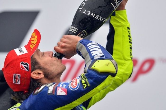 Pebalap Movistar Yamaha asal Italia, Valentino Rossi, meminum sampanye untuk merayakan kemenangannya pada balapan GP Inggris di Sirkuit Silverstone, Minggu (30/8/2015).