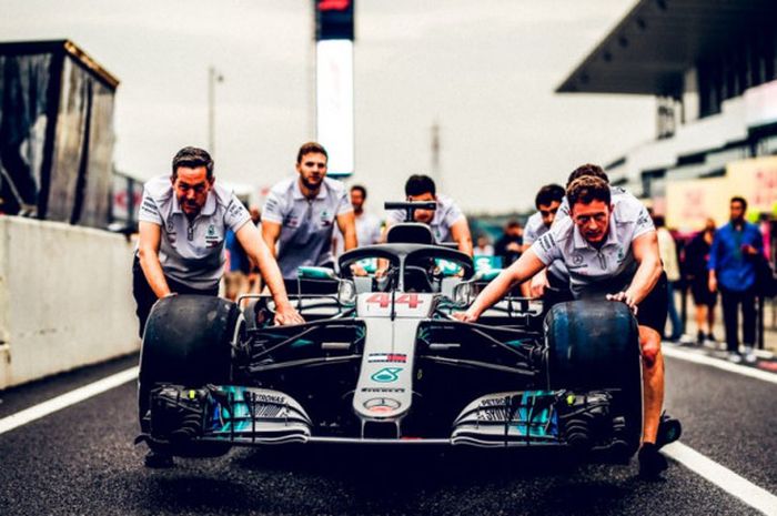 Kru tim Mercedes saat mempersiapkan mobil milik Lewis Hamilton jelang mengikuti sesi latihan bebas I F1 GP Jepang 2018, Jumat (5/10/2018).