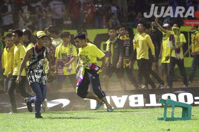 Suporter Persegres masuk ke lapangan, merusak, dan membakar jala gawang dan papan iklan usai pertandingan Persegres Gresik United kontra Persela Lamongan, Senin (5/6/2017).