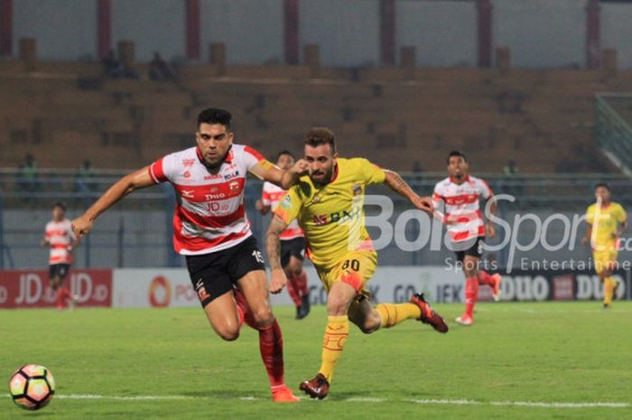 Fabiano Beltrame berjibaku dengan Paulo Sergio dalam laga Madura United kontra Bhayangkara FC di Stadion Gelora Bangkalan, Rabu (8/11/2017).