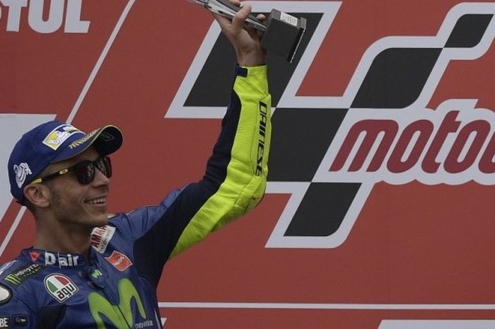 Pebalap Movistar Yamaha MotoGP asal Italia, Valentino Rossi, mengangkat trofi yang didapat setelah finis di urutan kedua pada balapan GP Argentina di Autodromo Termas de Rio Hondo, Minggu (9/4/2017).