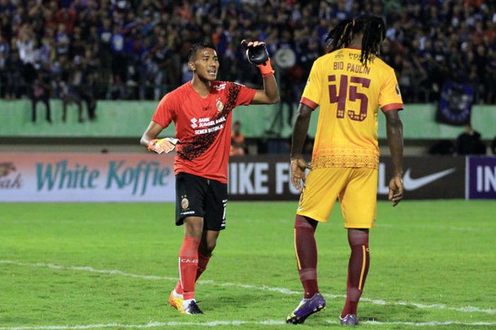 Kiper Sriwijaya FC, Teja Paku Alam menyemangati Bio Paulin yang melakukan pelanggaran di kotak penalti saat melawan Arema FC pada laga babak 8 besar Piala Presiden 2018 di Stadion Manahan, Solo, Minggu (4/2/2018).