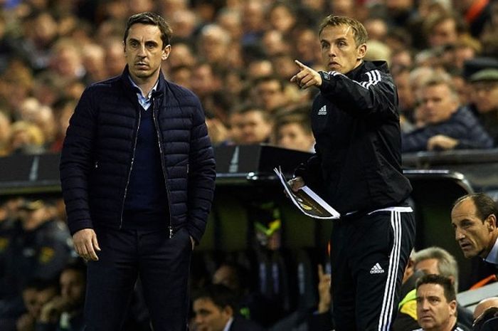 Gary Neville (kiri) bersama adik sekaligus asistennya, Phil Neville, saat memimpin Valencia menghadapi Real Madrid di Estadio Mestalla, Valencia,  pada 3 Januari 2016.