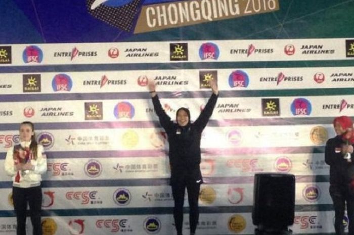 Aries Susanti Rahayu mengangkat kedua tangannya setelah naik di podium dan menjadi yang tercepat dalam kejuaraan dunia panjat tebing di Chongqing, China 