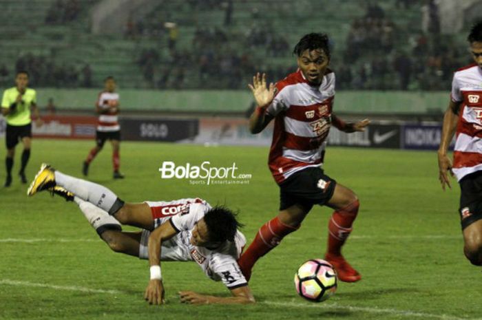 Pemain, Bali United, I Made Andhika Pradana (putih), terlempar setelah berduel dengan pemain Madura United, Alftah Faathier, pada babak perempat final Piala Presiden 2018, di Stadion Manahan, Solo, Sabtu (3/2/2018).
