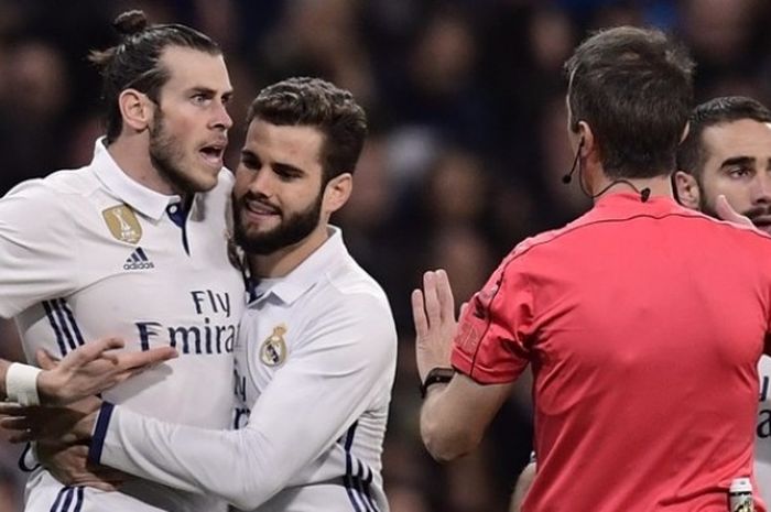 Bintang Real Madrid, Gareth Bale (kiri), berusaha diredam rekan setimnya, Nacho Fernandez (dua dari kiri), saat berdebat dengan wasit dalam pertandingan melawan Las Palmas di Santiago Bernabeu pada 1 Maret 2017.   