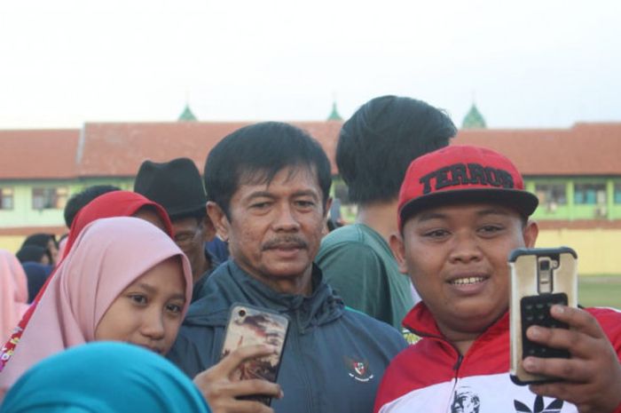 Pelatih Timnas U-19 Indonesia Indra Sjafri meladeni permintaan penggemar untuk berswafoto usai latihan rutin di Stadion Jenggolo, Minggu (8/7/2018).