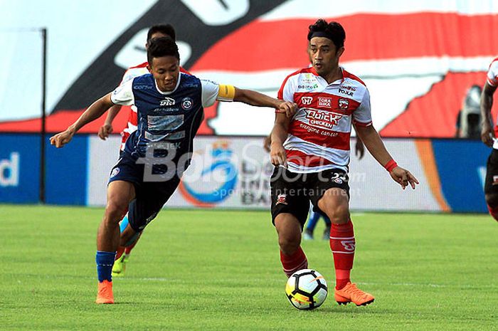 Penyerang Arema FC, Dendi Santoso (kiri), berupaya merebut bola dari penguasaan bek Madura United, Beni Wahyudi, dalam laga pekan kelima Liga 1 2018 di Stadion Gelora Ratu Pamelingan, Pamekasan, Sabtu (21/4/2018).