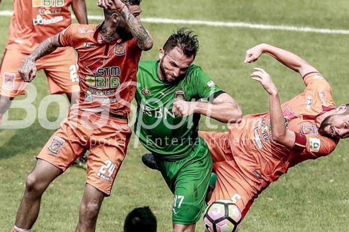 Penyerang Bhayangkara FC, Ilija Spasojevic, berebut bola dengan bek-bek Borneo FC, pada lanjutan laga Liga 1, 20 September 2017.