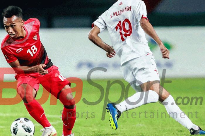   Pemain Timnas U-23 Indonesia, Irfan Jaya, mengecoh pemain Palestina pada pertandingan Grup A Asian Games 2018 di Stadion Patrtiot, 15 Agustus 2018.   