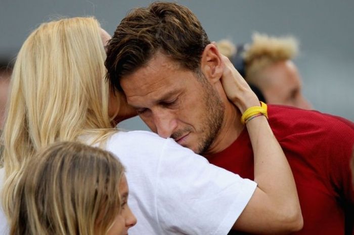 Kapten AS Roma, Francesco Totti (kanan), menangis di pundak sang istri, Ilary Blasi, setelah laga Serie A kontra Genoa di Stadion Olimpico, Roma, Italia, pada 28 Mei 2017.