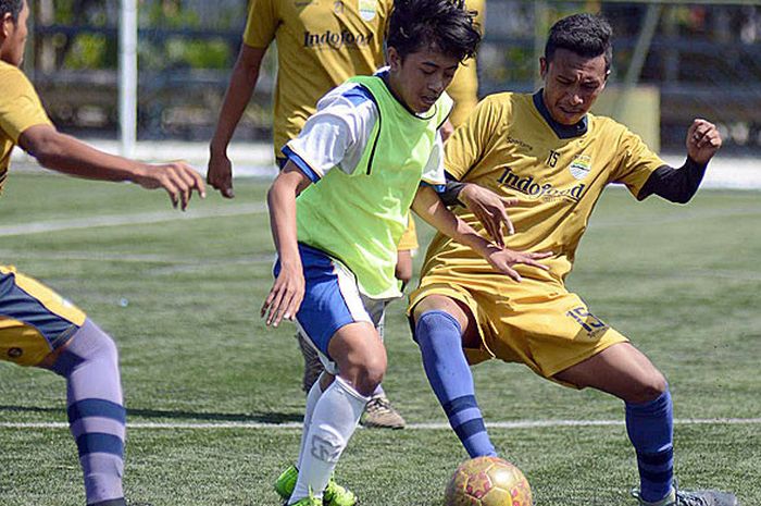 Pemain Arema FC U-16 (tengah) dikepung pemain Persib Bandung U-16 dalam laga hari kelima Festival Filanesia Kompetisi Liga 1 U-16 di Depok, Sabtu (14/07/2018).